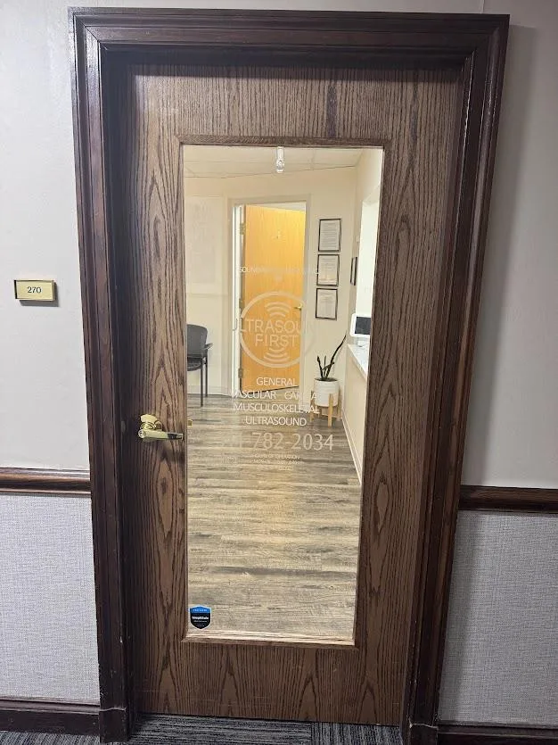 The suite door with the Ultrasound First logo etched on the glass